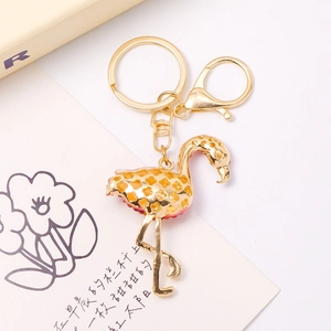 Hollow-out gold flamingo keychain with lobster clasp and ring shown at 45-degree angle
