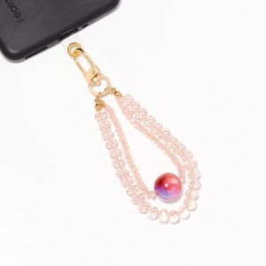 Detailed close-up of pink crystal beads phone charm with a golden zinc alloy lobster clasp