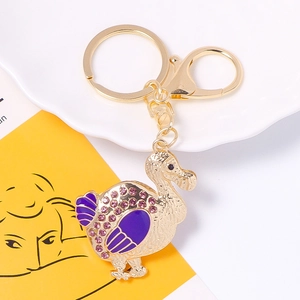 Golden dodo bird keychain with purple enamel wings and sparkling rhinestones