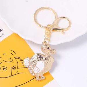 Close-up of golden dodo keychain with rhinestones and enamel details on decorative tray