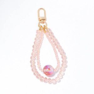Pink beaded phone charm with crystal beads and gold lobster clasp on white background
