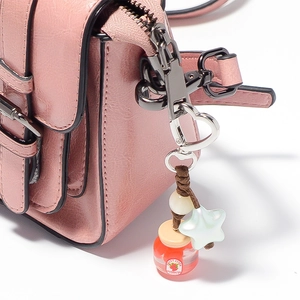 Borsa a tracolla in ecopelle rosa con chiusura a cuore e ciondolo a forma di fragola