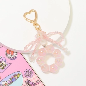 Detail of pink crystal beaded keychain with heart clasp and translucent ribbon bow decor