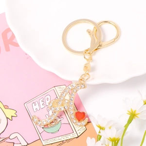Close-up of gold letter A keychain with rhinestones and a red heart charm
