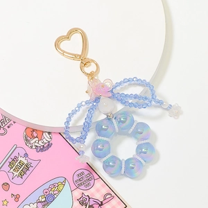 Detail of light blue iridescent beaded ring keychain with a crystal bow and heart clasp