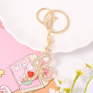 Golden crystal letter B keychain with sparkling rhinestones and a small red heart charm