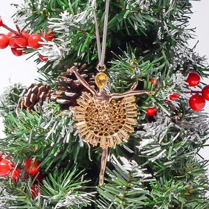 Pendentif ballerine aux cristaux ambrés sur sapin de Noël avec décor de pommes de pin