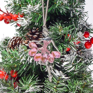 Close-up of ballet dancer Christmas ornament with pink crystals on a festive pine tree