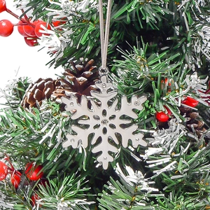 Vue détaillée du flocon de neige argenté avec strass suspendu sur un sapin de Noël