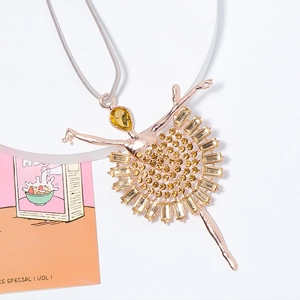 Détail d'un pendentif ballerine en or rose avec strass ambrés et cristaux brillants