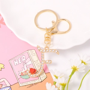 Detail of crystal letter F keychain with sparkling rhinestones and a small red heart charm
