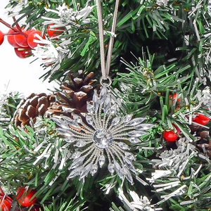 Détail macro d'un flocon de neige argenté avec cristaux suspendu au sapin de Noël