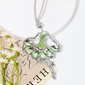 Detail of silver ballerina ornament with green crystals and gray silk ribbon hanger