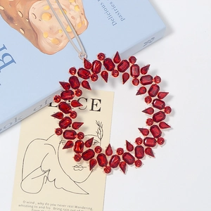 Macro detail of a red gemstone ring ornament with a gold base and grey ribbon tie