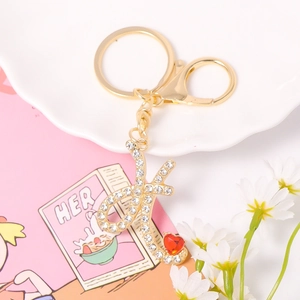 Close-up of letter K keychain with sparkling white rhinestones and a red heart gemstone