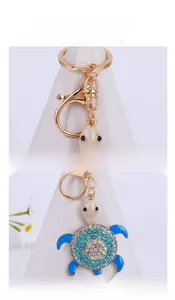 Macro shot of blue crystal turtle keychain with sparkling rhinestones and golden lobster clasp