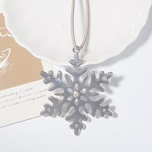 Vue détaillée d'un pendentif flocon de neige argenté avec strass et cordon gris élégant