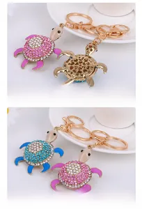 Macro shot of sparkling rhinestone turtle keychains with polished gold alloy details