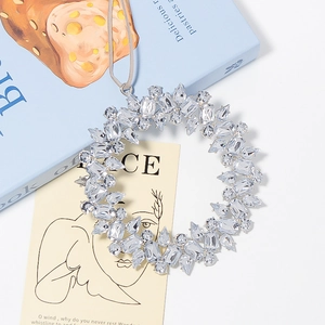 Macro detail of a sparkling rhinestone wreath pendant with a grey hanging cord