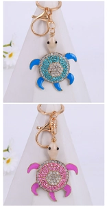 Close-up of pink and blue crystal turtle keychains with gold finish lobster clasps