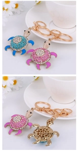 Detail of crystal sea turtle keychains showing enamel limbs and heart cutout design