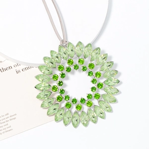 Macro detail of sunflower crystal pendant with marquise-cut light green stones