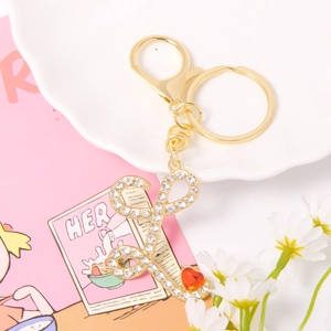 Detail of gold letter L keychain with sparkling rhinestones and a small red heart charm
