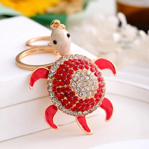 Exquisite gold turtle keychain with red and clear crystal rhinestones on a display