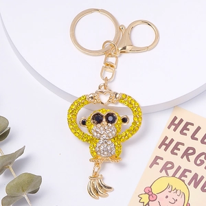 Detail of gold monkey keychain with sparkling yellow crystals and small banana charm