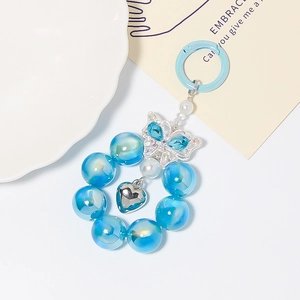 Detail eines blauen Schmetterlings-Schlüsselanhängers mit Perlen und Herzanhänger
