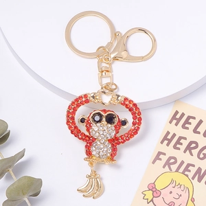 Detail of crystal monkey keychain with red rhinestones and hanging gold banana charms