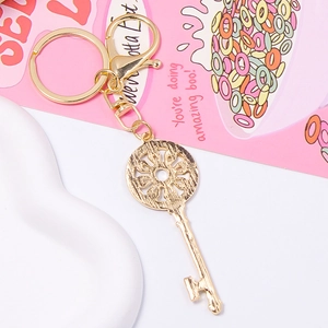 Golden key keychain with lobster clasp and round ring on decorative pink gift card
