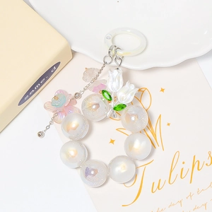 Détail du porte-clés perles tulipe avec perles blanches et pendentif fleur rose doux