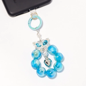 Detail eines blauen Schmetterling-Anhänger mit Perlen und Herzanhänger für Handy