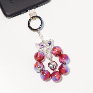 Details von lila schillernden Perlen-Handy-Anhänger mit Strass-Schmetterling und Herzanhänger
