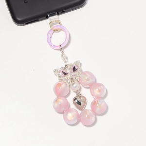 Detail der Handy-Handschlaufe mit rosa irisierenden Perlen, Herz-Anhänger und Kristall-Schmetterling