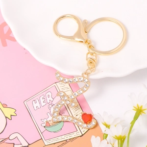 Detailed macro of gold alphabet keychain with crystals, red heart and lobster clasp
