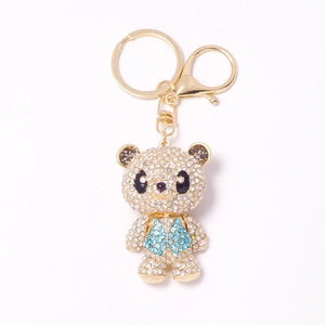 Sparkling rhinestone panda keychain with blue vest and golden clasp on white background