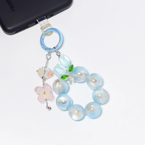 Détail d'une chaîne de téléphone en perles bleu clair avec breloque tulipe et anneau doré