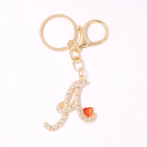 Luxurious gold metal letter A keychain with sparkling crystals and red heart gemstone