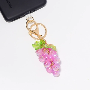 Detail van paarse hars druiven sleutelhanger met gouden ring en karabijnsluiting