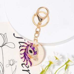 Detail of purple horse head keychain with sparkling rhinestones and golden ring