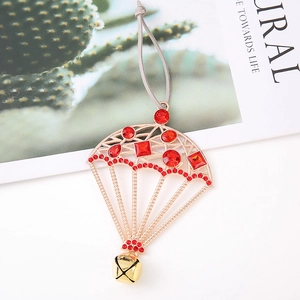 Detail of golden parachute ornament with red rhinestones and small metal bell pendant