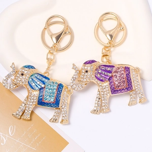 Detailed close-up of golden elephant keychains with blue and purple enamel and rhinestones