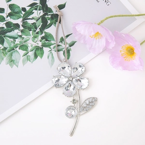 Detail of silver five-petal flower pendant with sparkling crystals and grey cord lanyard