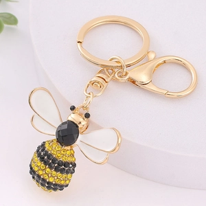 Rhinestone bee keychain with golden wings and sparkling crystal details on white pedestal