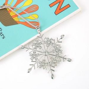 Macro detail of silver snowflake ornament with sparkling rhinestones and matte gray rope