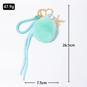 Mint green faux fur pompom keychain with gold letter K rhinestone butterfly charm and strap