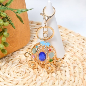 Goldener Kürbis-Kutschen Schlüsselanhänger mit Opal und Strass am weißen Ständer