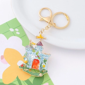 Detail showing the light blue fairy castle keychain with colorful enamel and gold metal ring